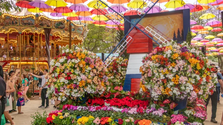 Arranjo floral com moinho holandês sob um céu de guarda-chuvas coloridos na Expoflora, em Holambra (SP)